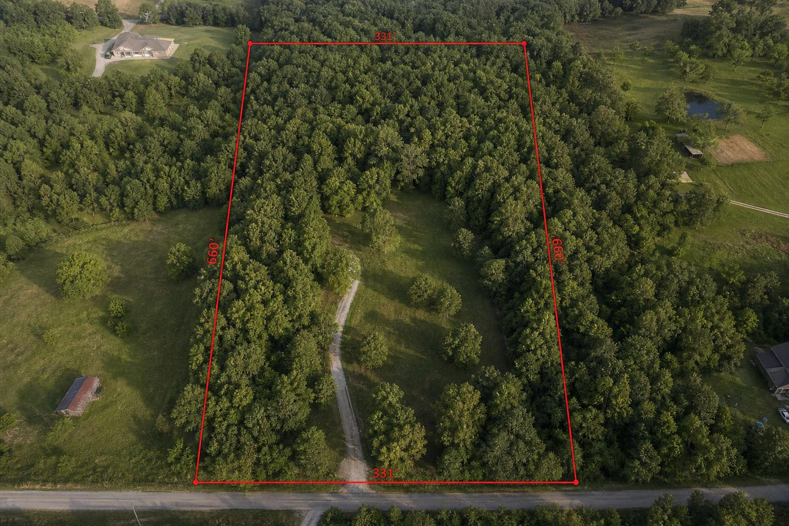 Aerial view of a wooded clearing with red estimated property boundary lines